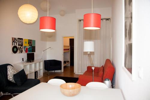 a living room with red chairs and a table at Acoteias Studio by be@home in Albufeira