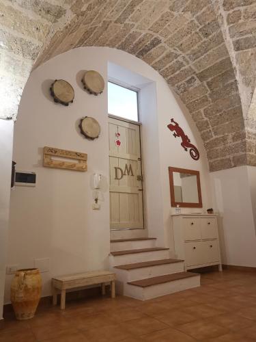 a room with stairs and a door with plates on the wall at B&B La volta di Fabio De Marco e Simona Saracino in San Pietro Vernotico
