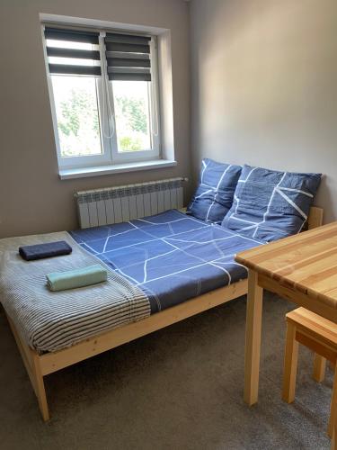 a bed with blue sheets in a room with a window at Nocleg pod Turbaczem in Nowy Targ