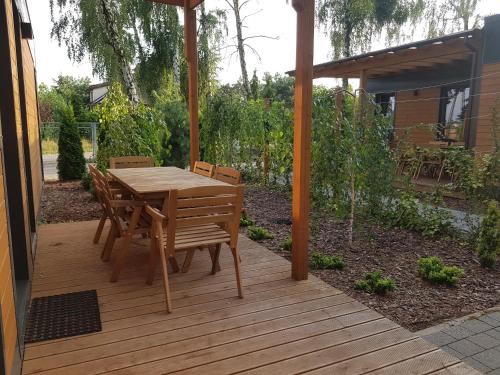 a wooden table and chairs on a wooden deck at JH1 domek M&M Apartments in Altanka