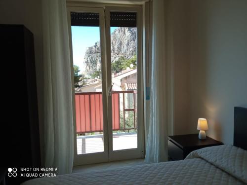 a bedroom with a bed and a sliding glass door at Royal View Apartment in Cefalù