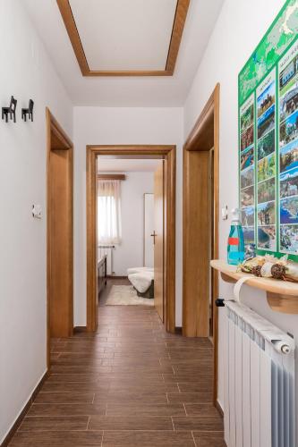 a kitchen with white walls and a wooden floor at Kuk Medin in Klanac