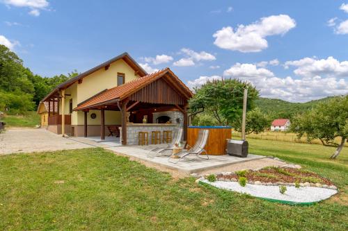a house with a patio and a tv in the yard at Kuk Medin in Klanac