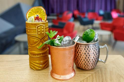 two cocktails sitting on top of a table at Qosmo Brasov Hotel in Braşov