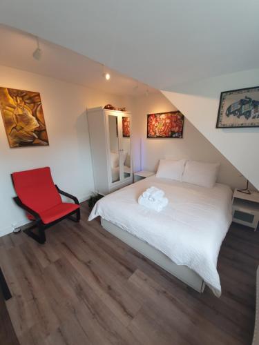 a bedroom with a bed and a red chair at Scheveningen Sea Side in The Hague