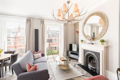 a living room with a couch and a fireplace at L-Spa Boutique Apartments in Leamington Spa