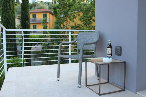 a chair sitting on a balcony with a bottle of wine at Dame di Toscana in Lastra a Signa