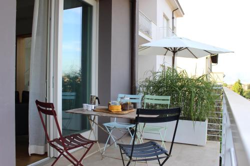 a table and chairs on a balcony with an umbrella at Dame di Toscana in Lastra a Signa