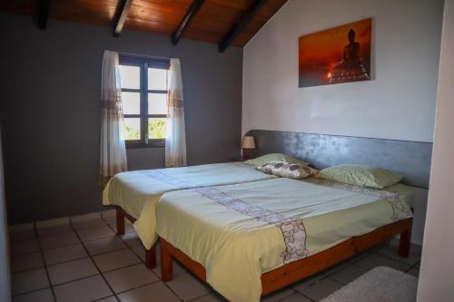 Schlafzimmer mit einem Bett und einem Fenster in der Unterkunft Casas Tipicas Candelaria Tabua in Ponta do Sol