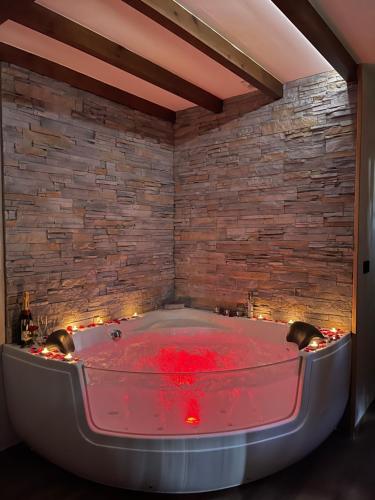 bañera de hidromasaje en una habitación con pared de ladrillo en La Era de Lario habitación con Jacuzzi, en Lario