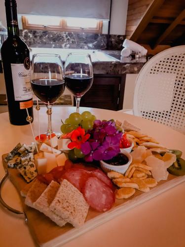 a plate of food with two glasses of wine at Hotel Vivenda dos Sonhos in Gramado