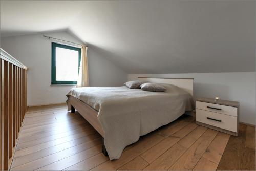 a bedroom with a bed and a wooden floor at Oliva in Murter
