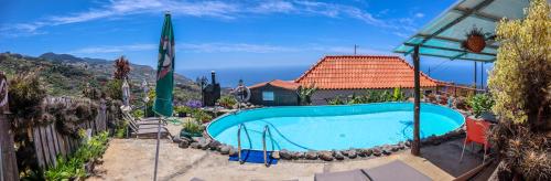 a swimming pool in front of a house at Casas Tipicas Candelaria Tabua in Ponta do Sol