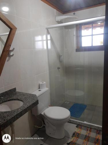 a bathroom with a toilet and a sink and a shower at Chalés do Apolinário in Tiradentes