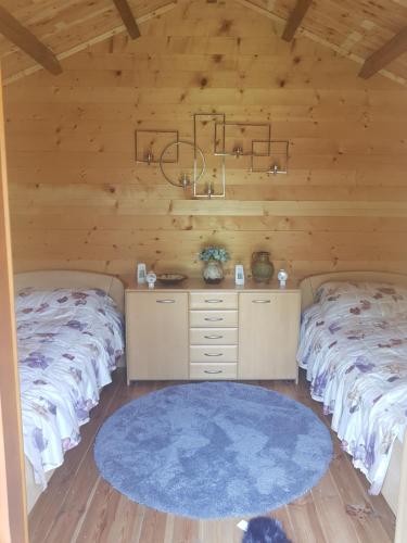 Habitación con 2 camas, paredes de madera y suelo de madera. en Bit Of Paradise, en Rîu de Mori