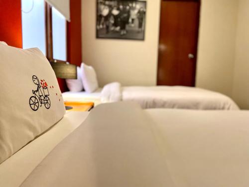a hotel room with two beds and a pillow with a bike on it at Peru Star Apart-Hotel in Lima