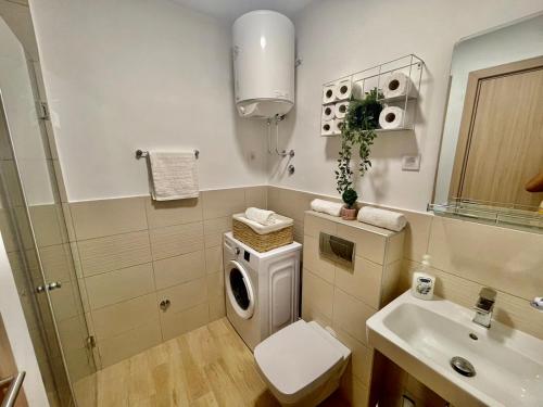 a bathroom with a washing machine and a sink at Olive Square Apartment Budva in Budva