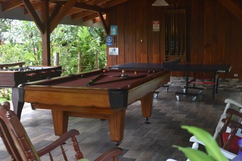a pool table in the middle of a room at Hotel Roca Negra Del Arenal in Fortuna