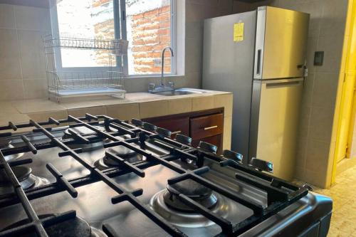a stove top oven in a kitchen with a refrigerator at Casa Marquita en el centro de Talpa de Allende. in Talpa de Allende