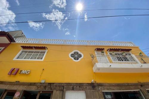 a yellow building with a fan on it at Casa Marquita en el centro de Talpa de Allende. in Talpa de Allende