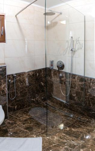 a shower with a glass door in a bathroom at Guest House Ćiro in Sarajevo