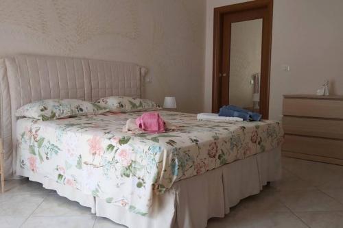 una camera da letto con un letto con copriletto rosa floreale di Casa Vacanza Letizia a San Felice a Cancello
