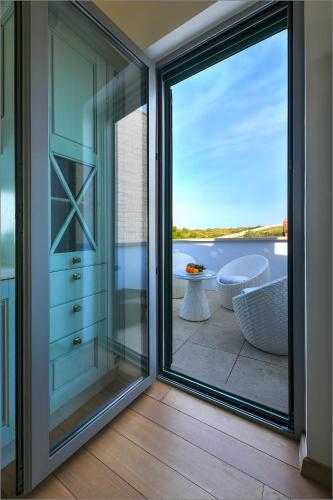 a sliding glass door leading to a balcony with a tub at Žakan in Murter
