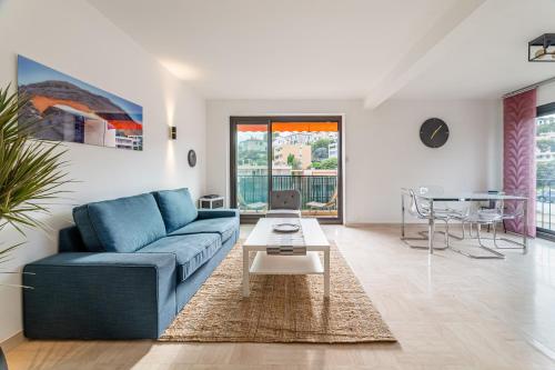 un salon avec un canapé bleu et une table dans l'établissement Leï Tapenié 2 par Dodo-a-Cassis, à Cassis