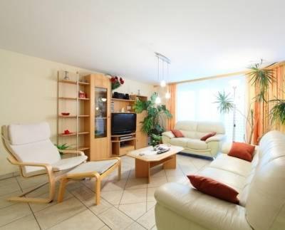 sala de estar con muebles blancos y TV en Haus Orta en Zermatt