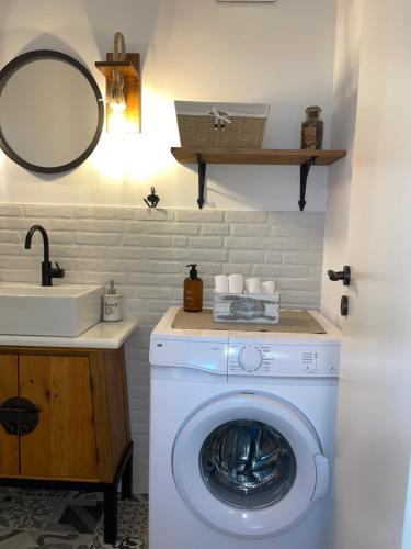 a washing machine in a bathroom with a sink at Philia Apartment in Artemida