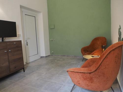 a living room with two chairs and a flat screen tv at La Tosca in Laiatico