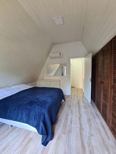 a bedroom with a bed with a blue blanket at Chalé do Bosque in Gramado