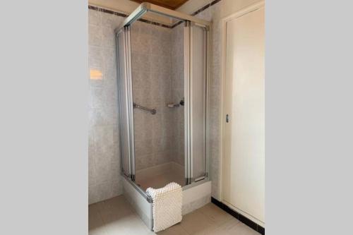 a shower with a glass door in a bathroom at Spacieux T2 à 100m des pistes & WIFI ultra rapide in Saint-Chaffrey