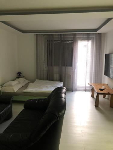 a living room with a couch and a bed at Bezsó apartman in Hajdúszoboszló