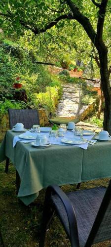 a green table with plates and glasses on it at Filoxenia in Tsagarada