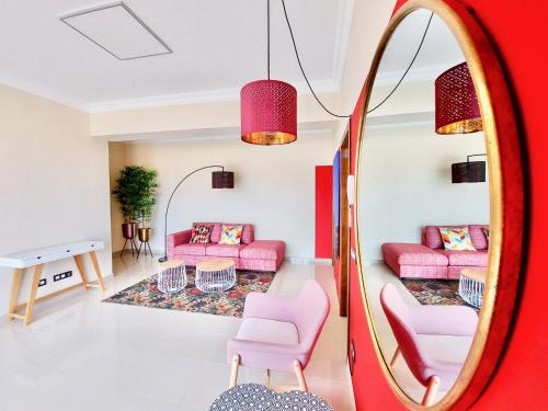 sala de estar con muebles de color rosa y espejo. en AROMAS Suites Attic, en Puerto de la Cruz