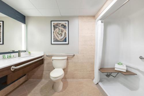 a bathroom with a toilet and a sink at Holiday Inn & Suites Ocean City by IHG in Ocean City