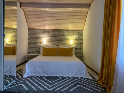 a bedroom with a large white bed with yellow pillows at Зоряні Карпати in Slavske