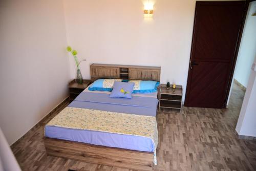 a bedroom with a bed with blue sheets and blue pillows at Casa Rosa in Flic-en-Flac