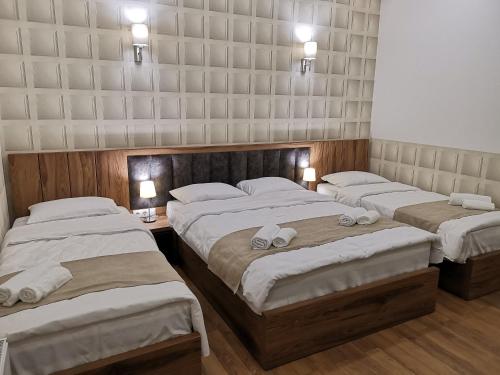 a bedroom with three beds with towels on them at 3 Rooms Hotel in Tbilisi City