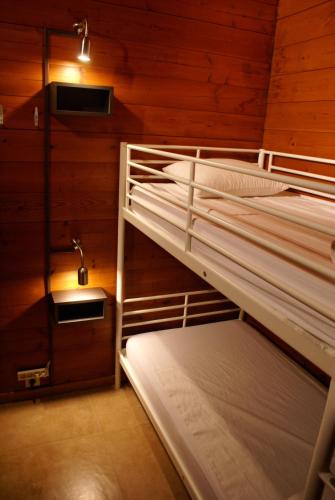 two bunk beds in a room with wooden walls at Gite L'unité in Hour