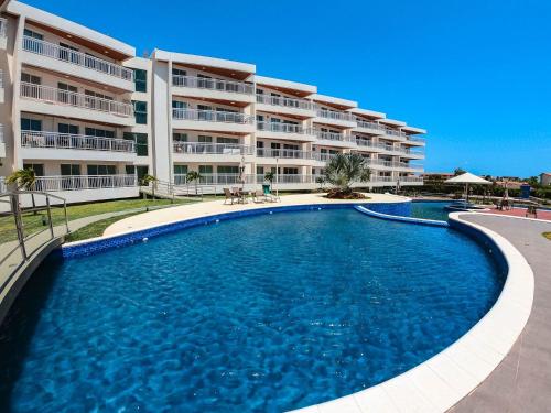 a large swimming pool in front of a building at Solarium Residence no Porto das Dunas in Fortaleza