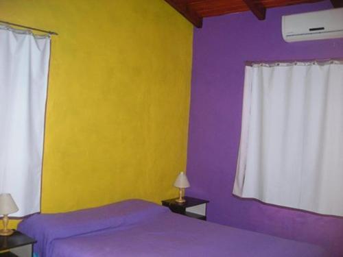 a bedroom with purple and yellow walls and a bed at Cabañas en Termas de Guaviyú, Paysandú, Uruguay in Quebracho