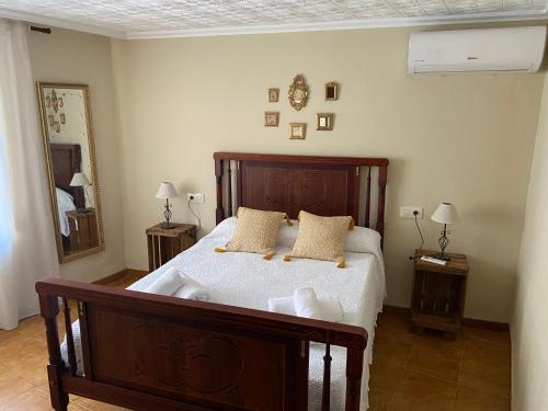 1 dormitorio con 1 cama grande de madera y 2 almohadas en Casa Monedero, en La Recueja