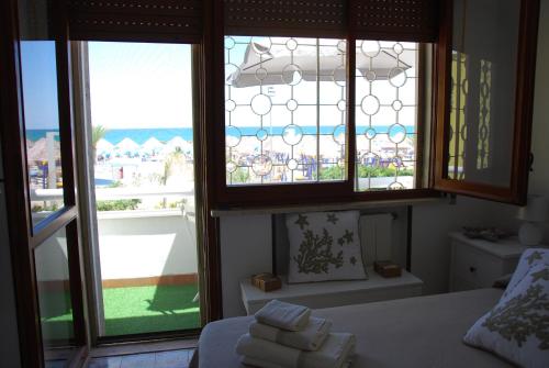 una camera da letto con finestre affacciate sulla spiaggia di Villa Ada a Francavilla al Mare