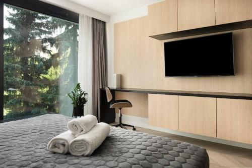 a bedroom with two towels on a bed with a flat screen tv at EASY RENT Apartments - GOLD 36, Basen & SPA, Centrum Free Parking 24h Check-in in Lublin