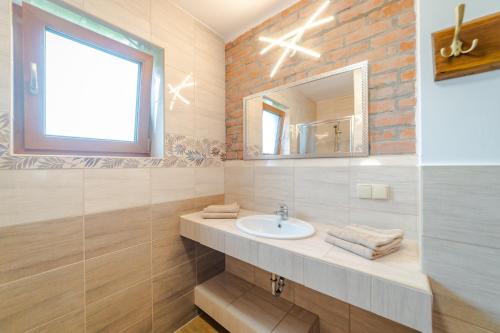 a bathroom with a sink and a mirror at Mazurskie El Dorado in Mikołajki
