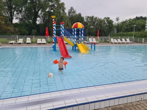 a young boy playing in a swimming pool at Rent & Relax in Mol