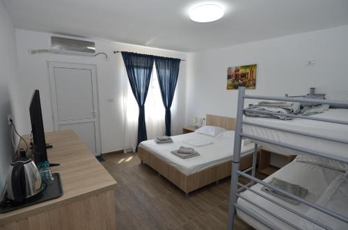 a bedroom with a bunk bed and a desk with a television at Casa Robinson in Vama Veche