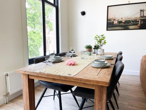 a dining room with a wooden table and chairs at LVM Stays in The Hague